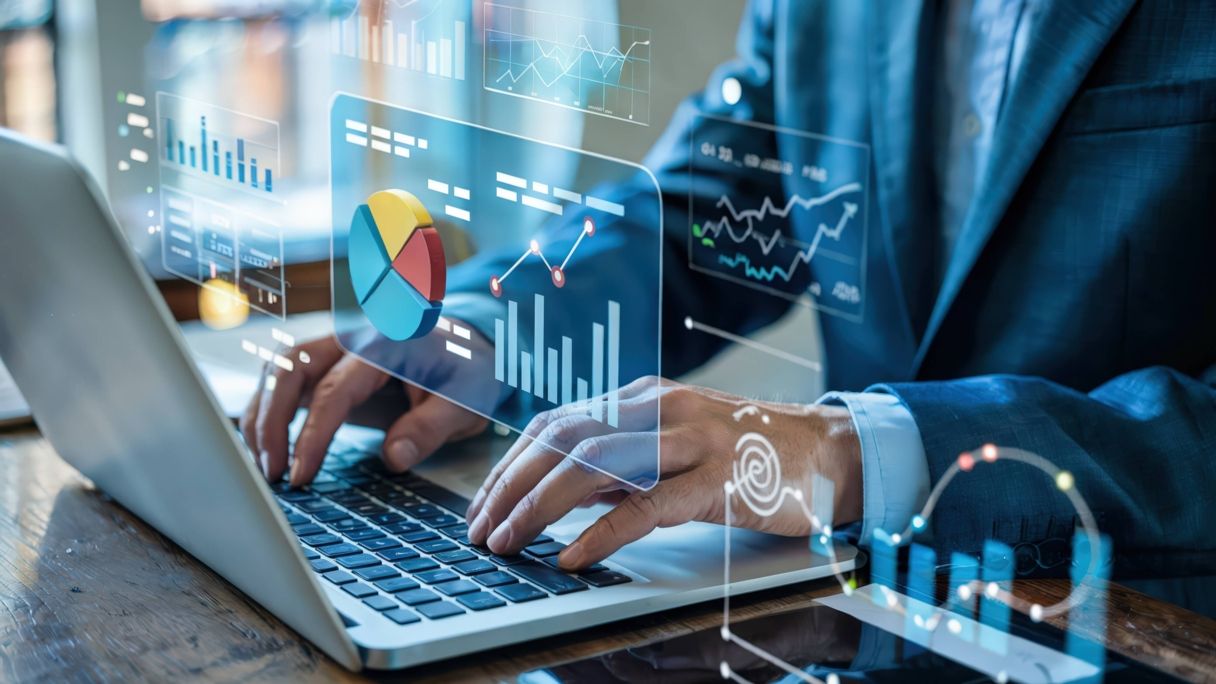 Person working on a laptop with floating charts and graphs representing data analytics.